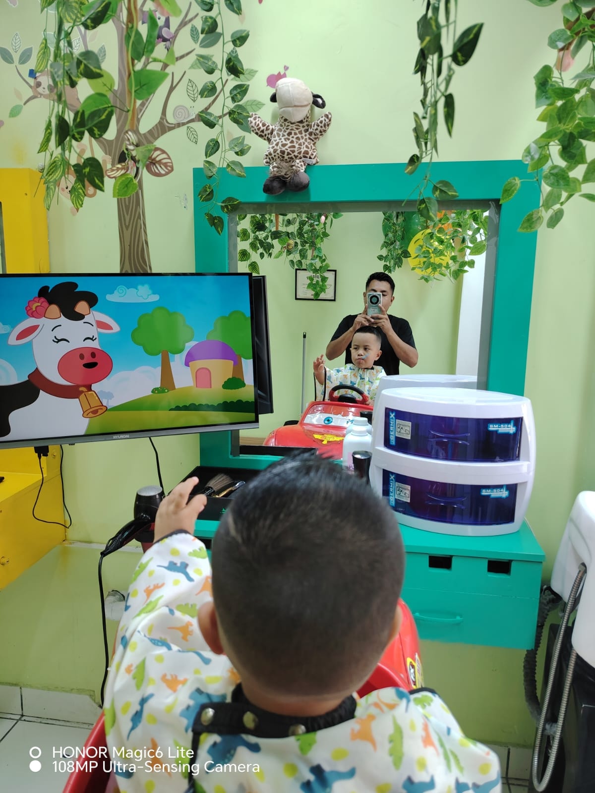 Niño en auto infantil mirando dibujos animados