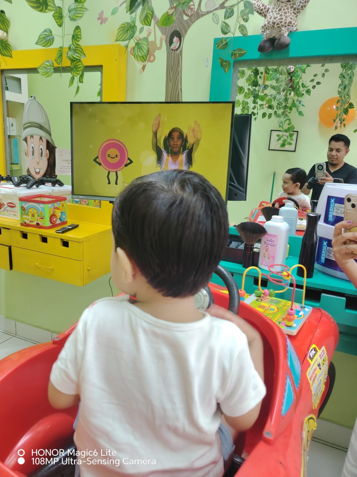 Niño disfrutando su corte frente a dibujos animados