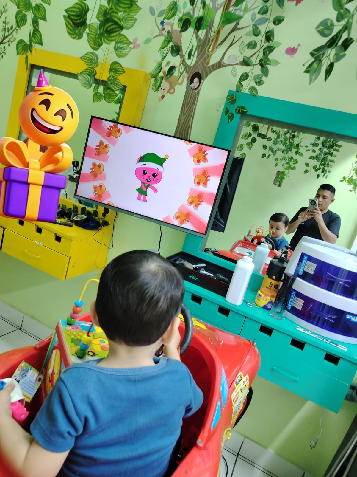 Niño en auto infantil junto a la zona de entretenimiento